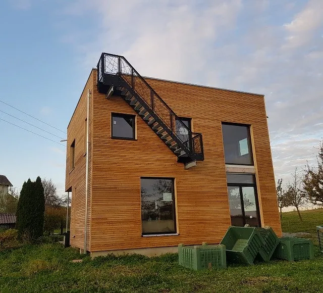 Neubau Einfamilienhaus in Holzbauweise mit vorgefertigten Ständerwänden und Decken, rechteckig, mit Außentreppe und großen Fenstern