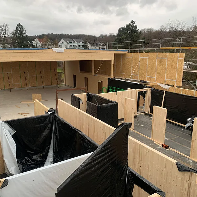Baustelle eines Feuerwehrgerätehauses in Konstanz-Dettingen mit Holzrahmenkonstruktion und schwarzen Schutzfolien auf den Wänden